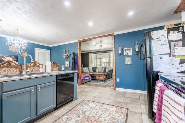 kitchen with baseboards, a chandelier, light countertops, black appliances, and a sink