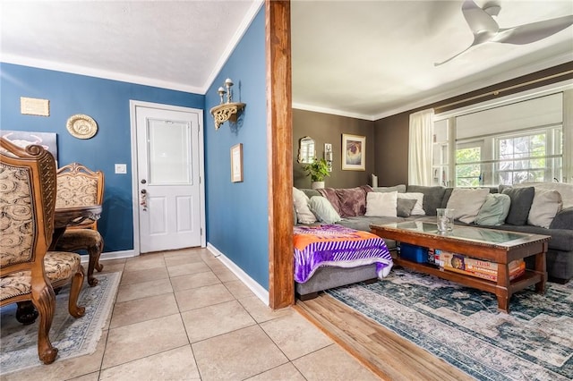 living room featuring ornamental molding, baseboards, and light tile patterned floors