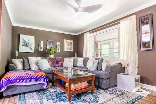 living area with baseboards, a ceiling fan, and wood finished floors