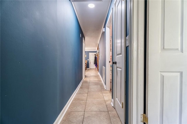 hall with baseboards and light tile patterned flooring