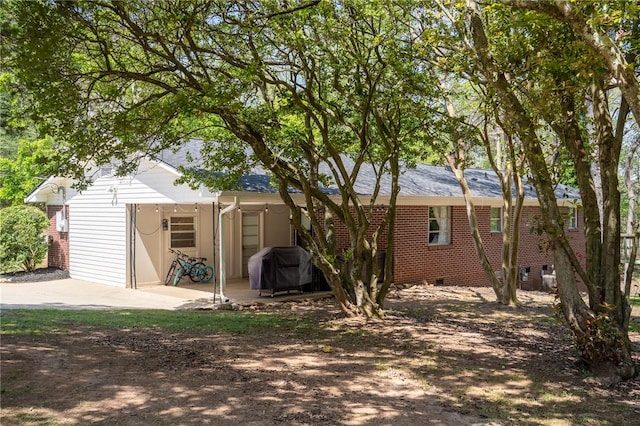 rear view of property with a patio area and brick siding