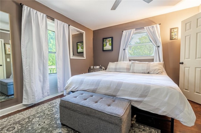 bedroom featuring multiple windows, wood finished floors, and a ceiling fan