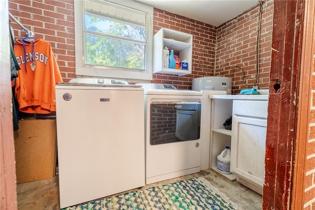 laundry room with brick wall, independent washer and dryer, and laundry area
