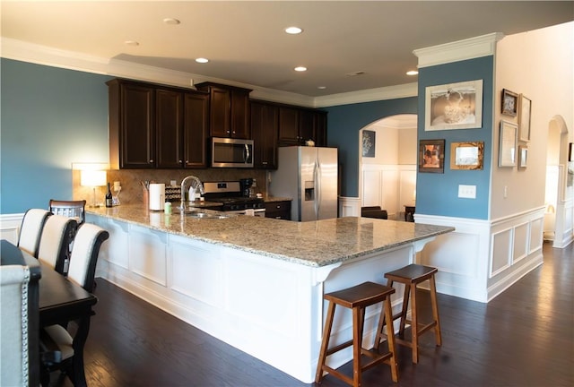 24 Dunsborough Dr, Simpsonville, SC 29680 - kitchen featuring stainless steel appliances, arched walkways, crown molding, wainscoting, and a peninsula