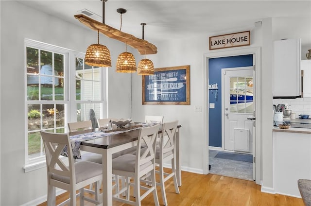 dining area with light wood-style floors and baseboards