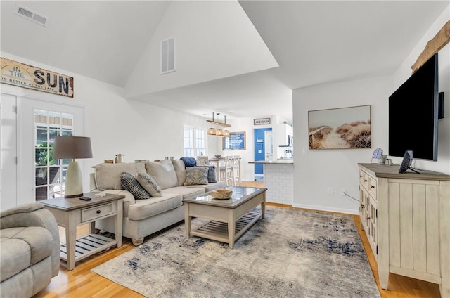living area featuring visible vents, wood finished floors, and a healthy amount of sunlight