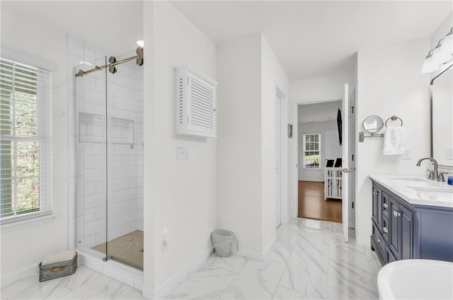bathroom with a stall shower, marble finish floor, baseboards, and plenty of natural light