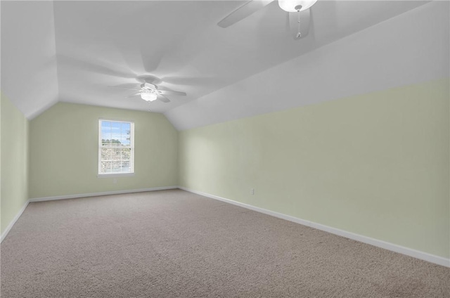 additional living space featuring light carpet, ceiling fan, baseboards, and vaulted ceiling