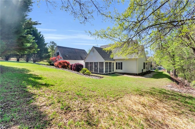 back of house with a sunroom and a lawn