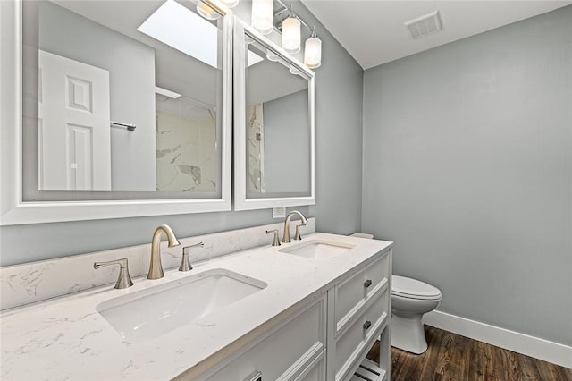 full bathroom with toilet, a sink, visible vents, and baseboards