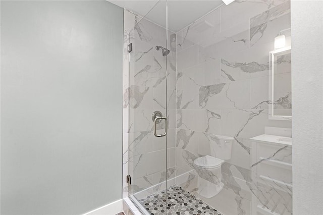 bathroom with a marble finish shower and toilet