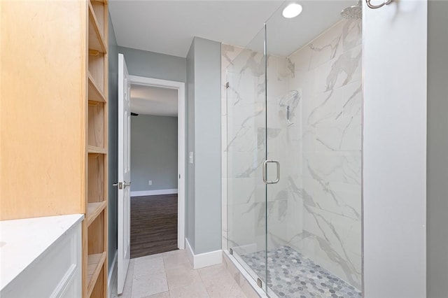 bathroom with baseboards, vanity, and a marble finish shower