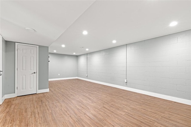 finished below grade area with recessed lighting, baseboards, and light wood-type flooring