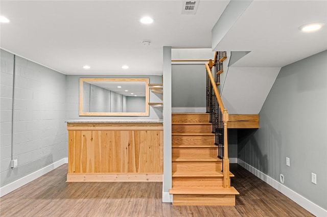 interior space with baseboards, wood finished floors, recessed lighting, and stairs