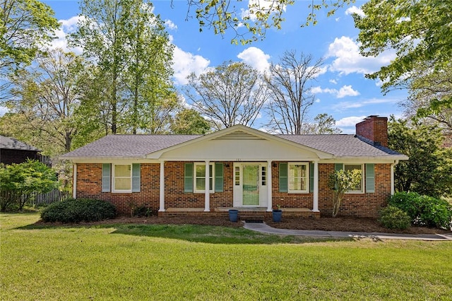 ranch-style house featuring a chimney, a front lawn, and brick siding