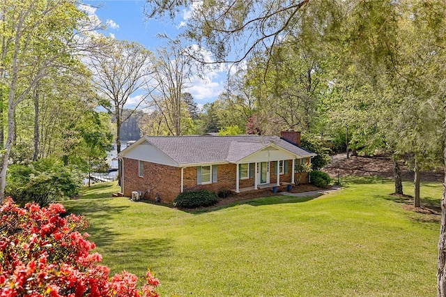 view of front of property with a chimney, a front lawn, and brick siding