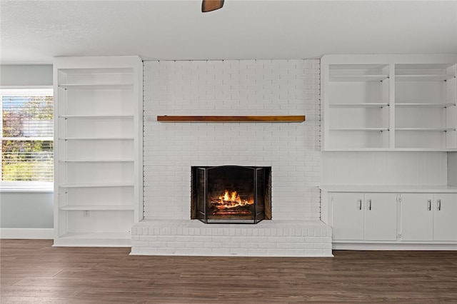 room details with baseboards, a brick fireplace, and wood finished floors