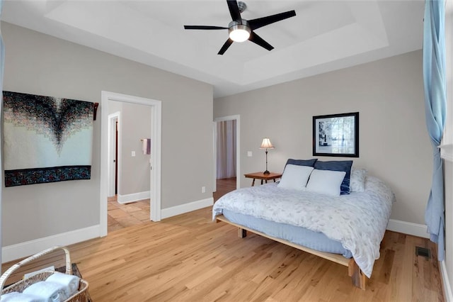 101 Cabernet Way, Travelers Rest, SC 29690 - bedroom featuring ceiling fan, a tray ceiling, visible vents, baseboards, and wood finished floors