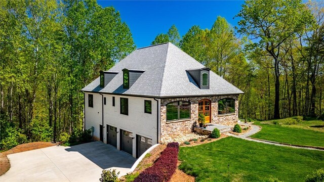 101 Cabernet Way, Travelers Rest, SC 29690 - view of side of property featuring driveway, a lawn, stone siding, and a garage