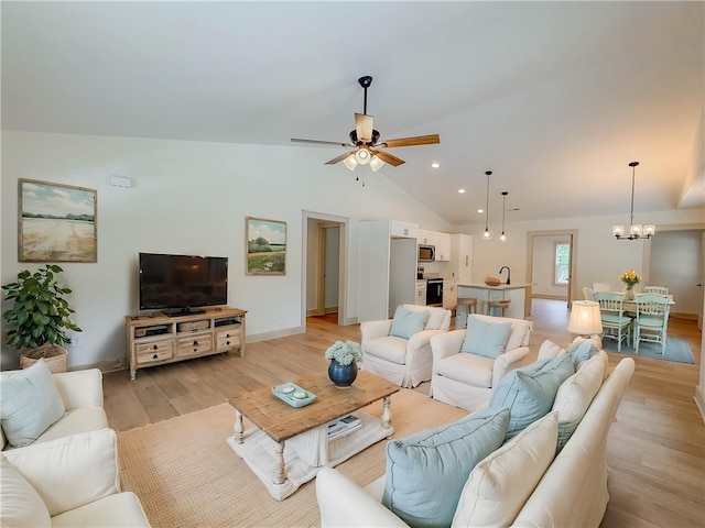 living room with a ceiling fan, vaulted ceiling, light wood-style floors, a chandelier, and baseboards