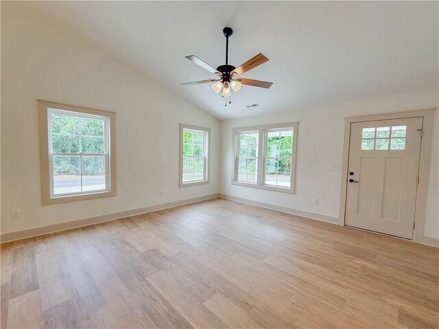 unfurnished living room with healthy amount of natural light, light wood finished floors, lofted ceiling, and ceiling fan