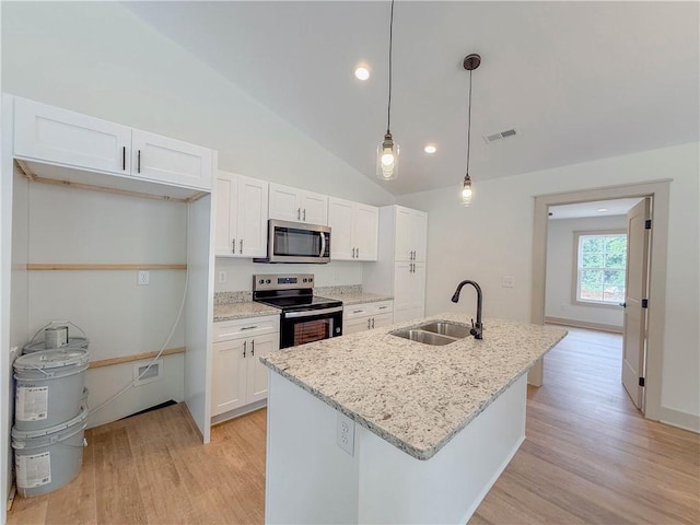 kitchen with appliances with stainless steel finishes, a sink, white cabinetry, light wood-type flooring, and an island with sink