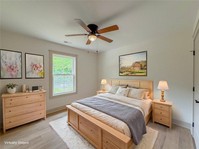 bedroom featuring light wood finished floors, baseboards, and ceiling fan