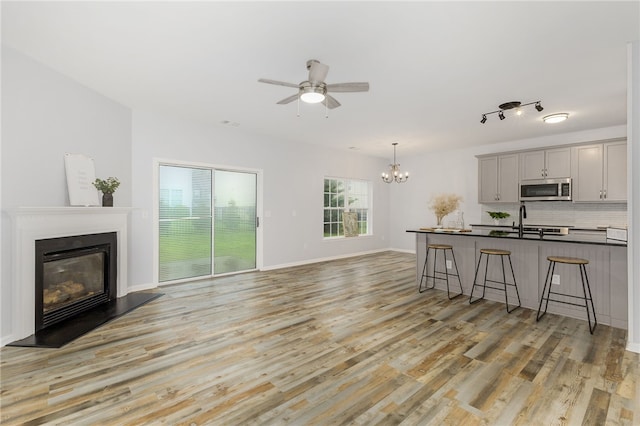 101 Pin Oak Ct, Easley, SC 29642 - kitchen with light wood-style flooring, gray cabinets, stainless steel microwave, and a breakfast bar area