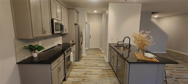101 Pin Oak Ct, Easley, SC 29642 - kitchen with appliances with stainless steel finishes, dark countertops, light wood-type flooring, a sink, and gray cabinetry