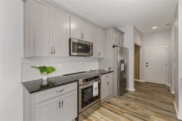 101 Pin Oak Ct, Easley, SC 29642 - kitchen with backsplash, appliances with stainless steel finishes, baseboards, dark stone countertops, and light wood-style floors