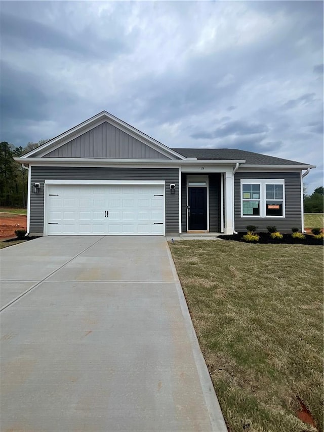 single story home featuring a garage, a front yard, and concrete driveway