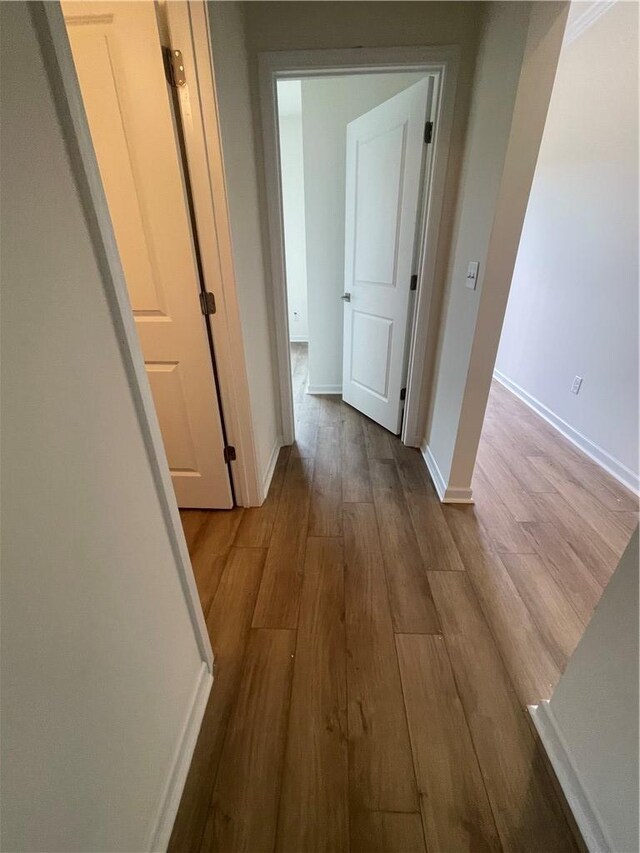 hall with wood finished floors and baseboards