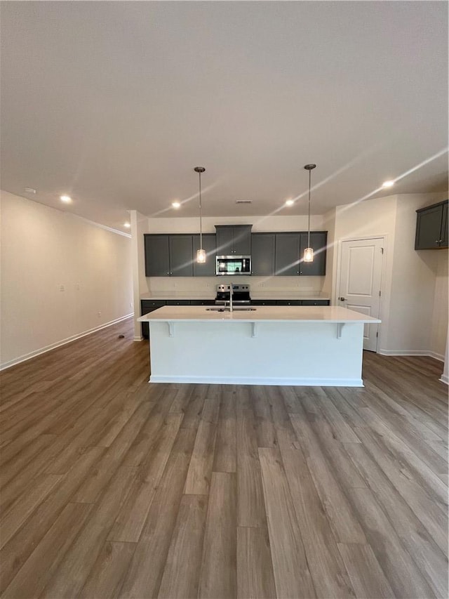kitchen with stainless steel appliances, light countertops, a sink, and recessed lighting