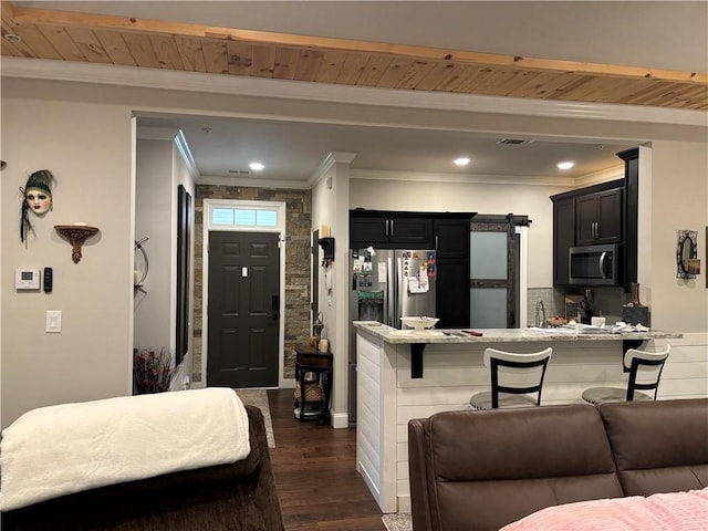 kitchen with stainless steel appliances, a peninsula, dark wood finished floors, dark cabinetry, and crown molding