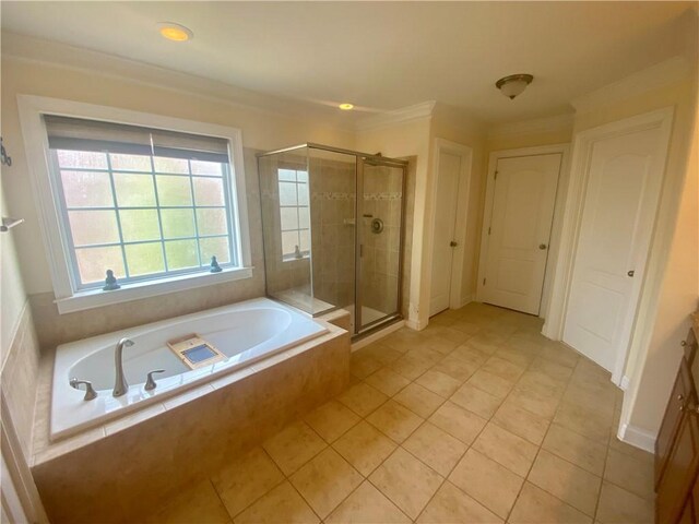 bathroom with a shower stall, ornamental molding, a bath, and tile patterned floors