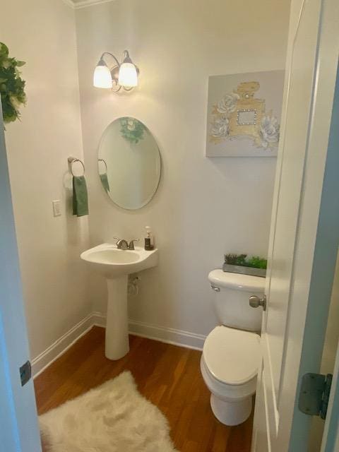 bathroom with baseboards, toilet, and wood finished floors