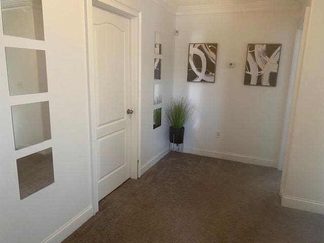 hall featuring baseboards, carpet flooring, and ornamental molding