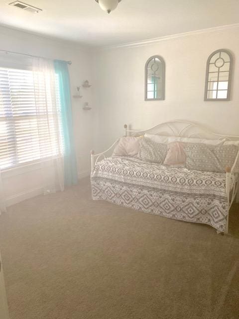 carpeted bedroom featuring visible vents and ornamental molding