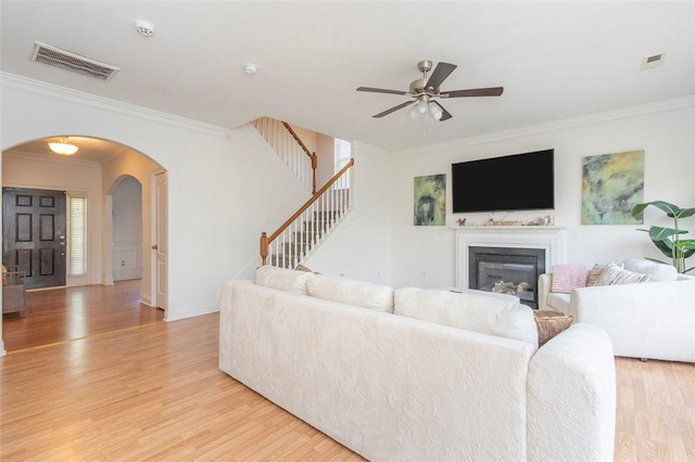 118 Easy Gap Rd, Anderson, SC 29621 - living area with arched walkways, light wood-type flooring, ceiling fan, crown molding, and a glass covered fireplace