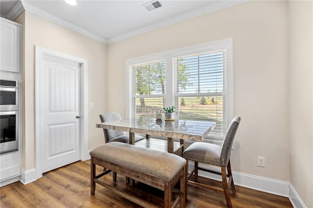 dining space featuring baseboards, crown molding, wood finished floors, and visible vents