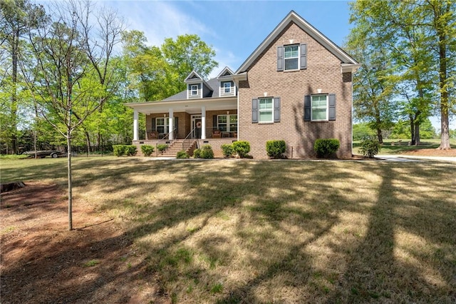 view of front facade featuring a front lawn, brick siding, and covered porch