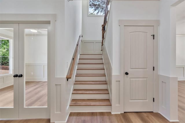 138 Jackson Cir, Anderson, SC 29625 - stairway featuring french doors, wood finished floors, a wainscoted wall, and a decorative wall