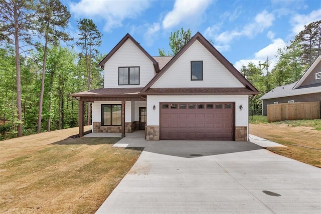 138 Jackson Cir, Anderson, SC 29625 - modern farmhouse with fence, a front lawn, concrete driveway, an attached garage, and stone siding