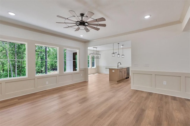 138 Jackson Cir, Anderson, SC 29625 - unfurnished living room featuring light wood-style flooring, a decorative wall, a wainscoted wall, and ceiling fan with notable chandelier