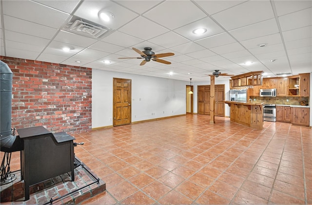 234 Chandlers Ferry Dr, Hartwell, GA 30643 - unfurnished living room featuring a wood stove, visible vents, baseboards, a paneled ceiling, and ceiling fan