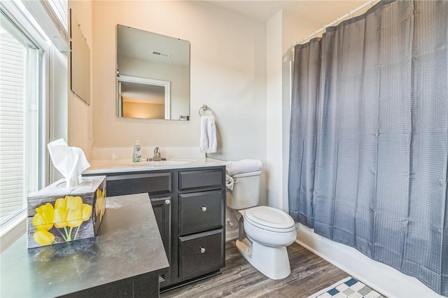 full bath with toilet, vanity, visible vents, and wood finished floors