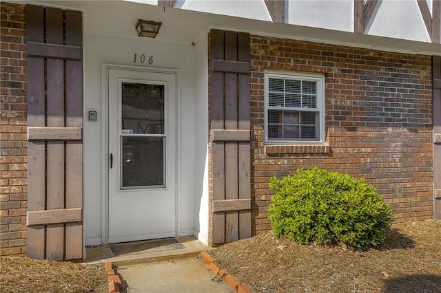 view of exterior entry with brick siding