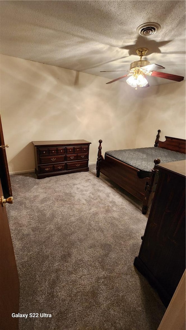 carpeted bedroom with a ceiling fan, a textured ceiling, and visible vents