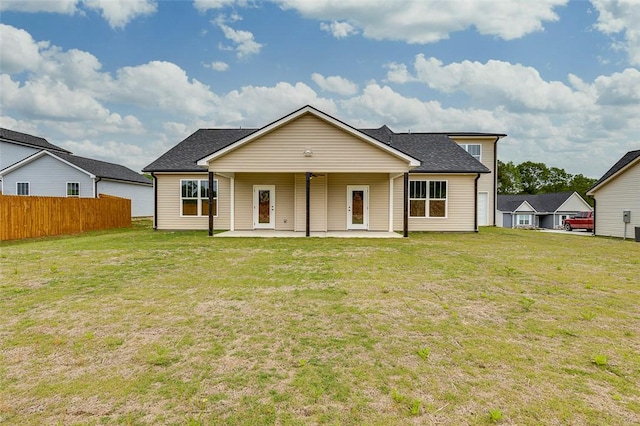 rear view of property featuring a patio and roof with shingles