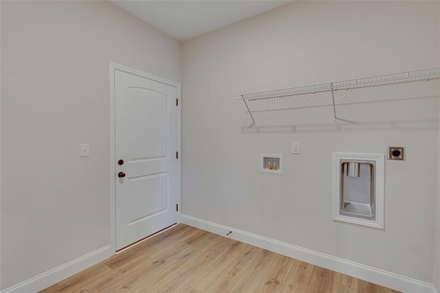 clothes washing area with hookup for an electric dryer, hookup for a washing machine, light wood-type flooring, and baseboards